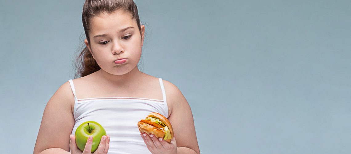 Portrait of a young beautiful girl holding a red Apple in one ha