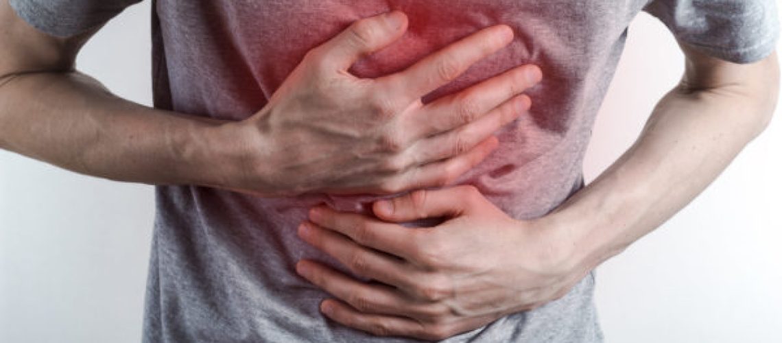 The concept of heartburn. A man holds on to his chest . Acid in