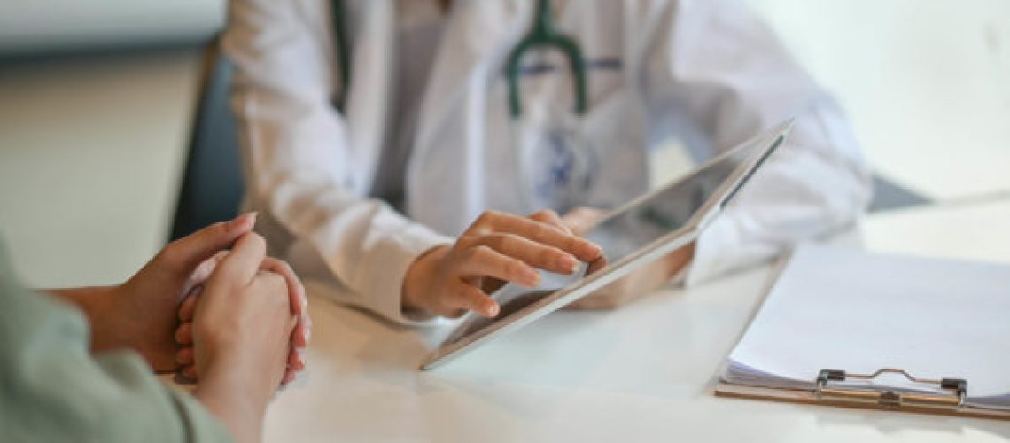 Shot of a doctor showing a patient some information on a digital tablet